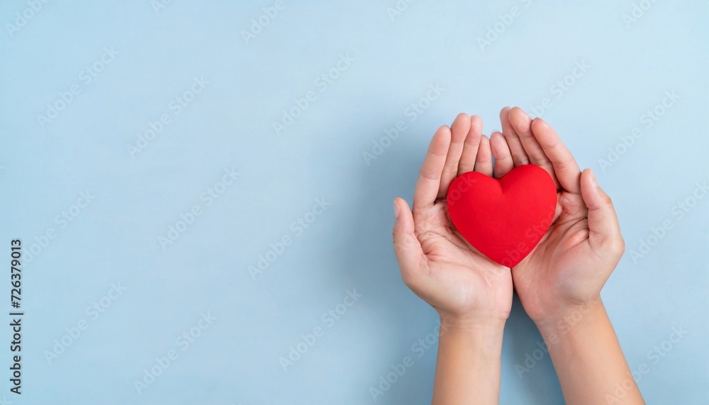 Hands holding red heart on blue background. World heart day. Hands holding red heart on blue background. World heart day.