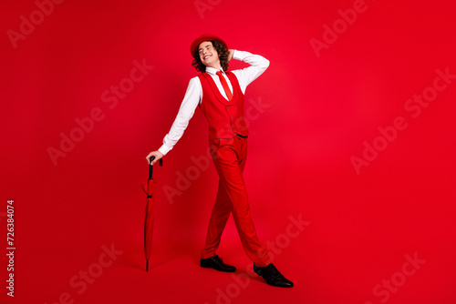 Full length body photo of handsome boyfriend seems to be happy at his birthday party in vintage outfit isolated on red color background