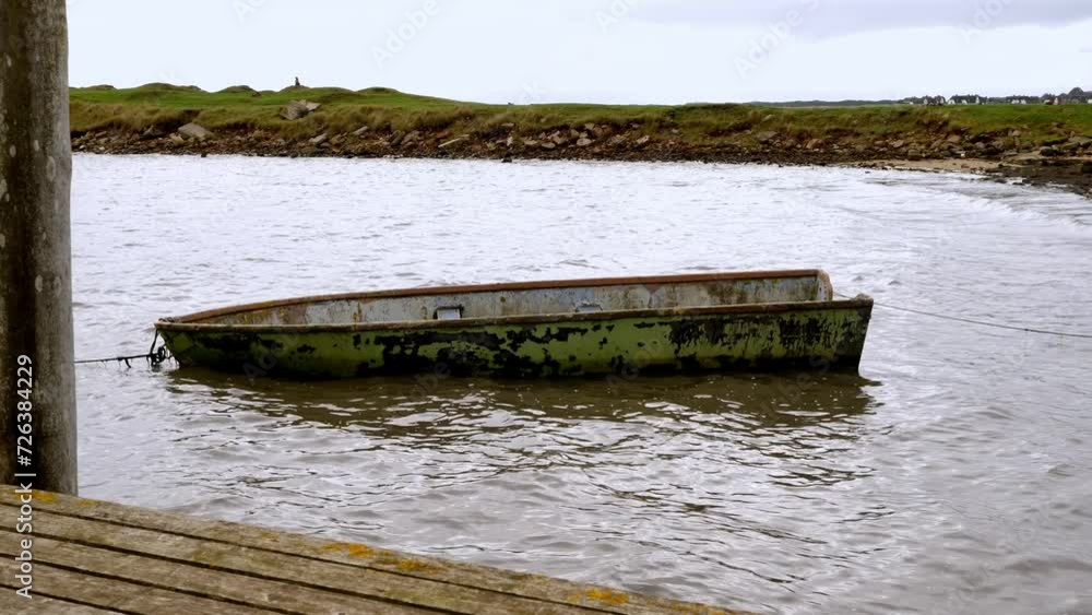 Small boat moored at the pier in Sylt, Germany. The boat moves smoothly on the waves Small boat moored at the pier in Sylt, Germany. The boat moves smoothly on the waves