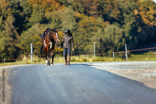 Girl rider goes riding with her horse ready to ride. photo