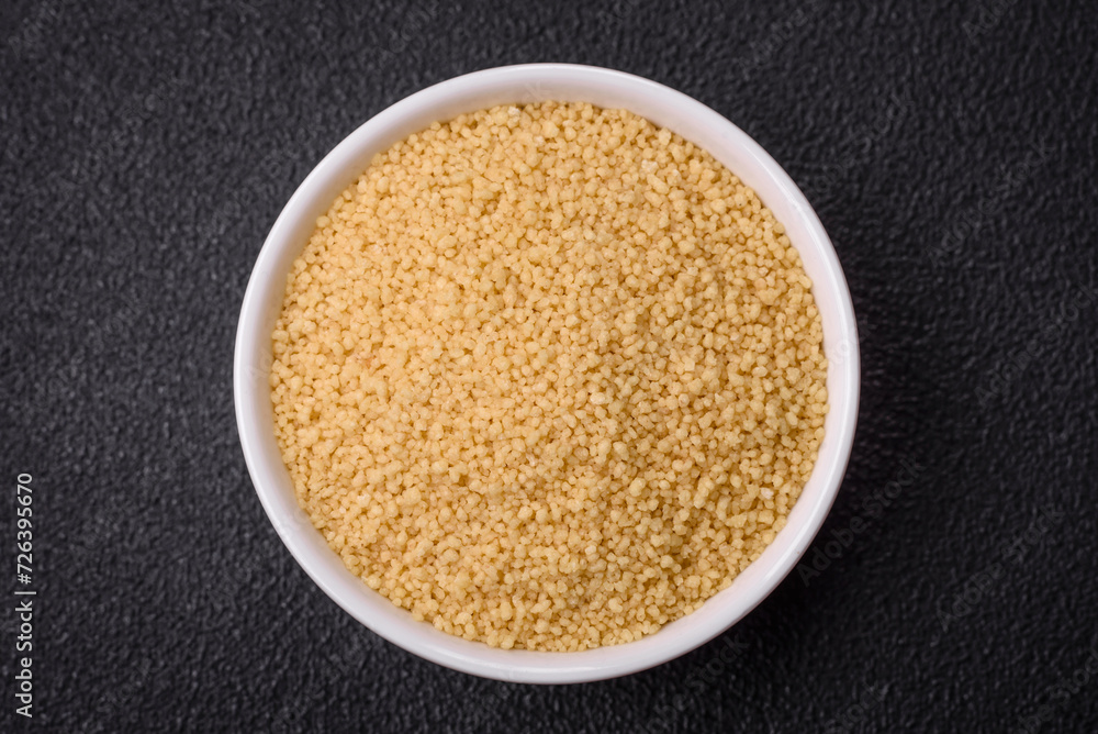 Wheat porridge couscous grains on a dark concrete background Wheat porridge couscous grains on a dark concrete background