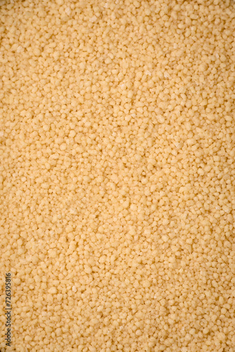 Wheat porridge couscous grains on a dark concrete background