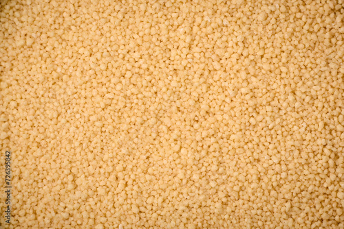 Wheat porridge couscous grains on a dark concrete background