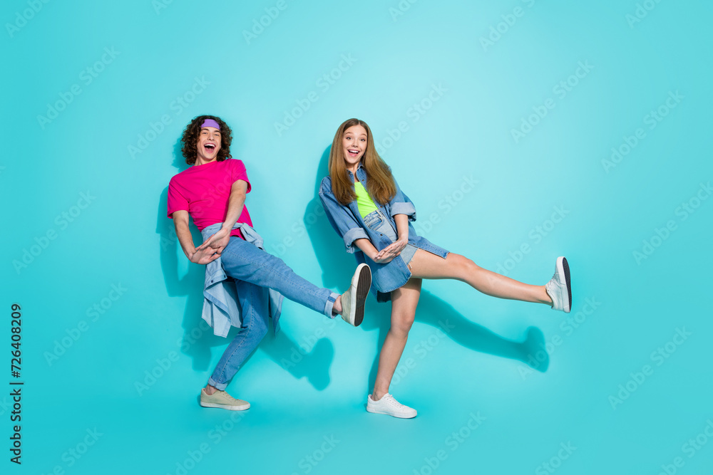 Full length photo of synchronized motion couple girlfriend and boyfriend dance together boogie woogie step isolated on cyan color background