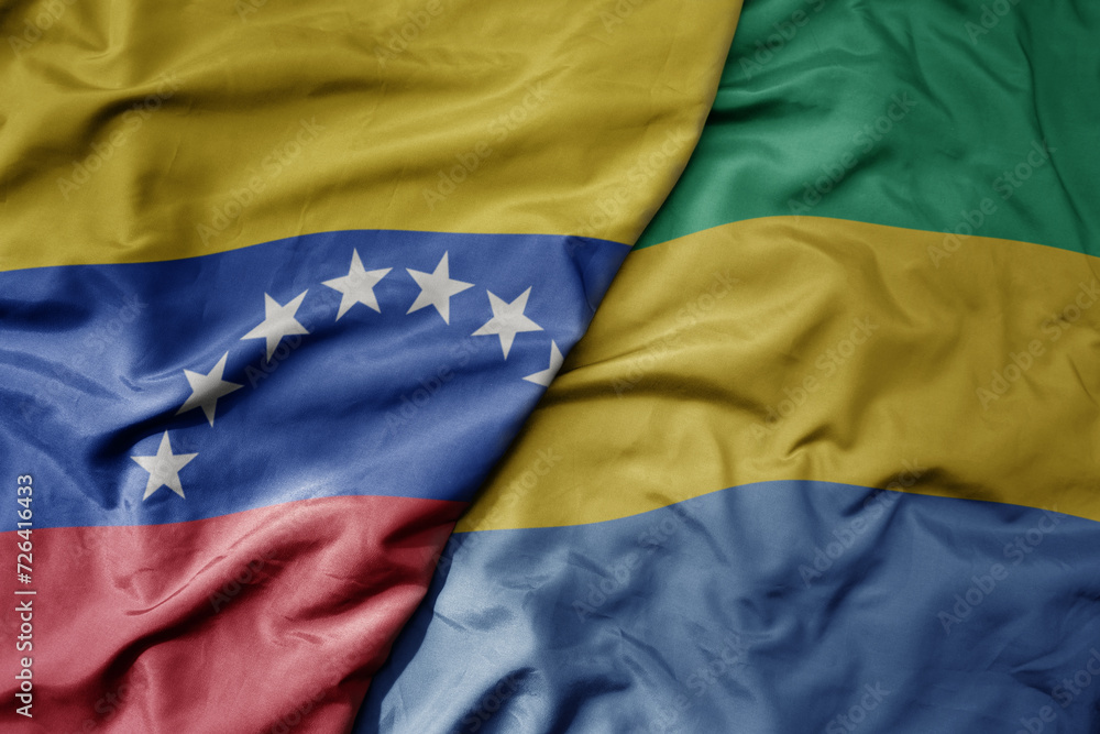 Fototapeta premium big waving national colorful flag of gabon and national flag of venezuela . macro