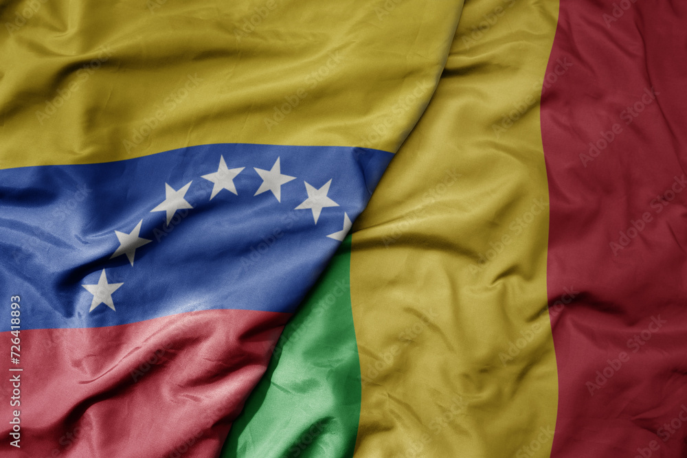 Fototapeta premium big waving national colorful flag of mali and national flag of venezuela . macro