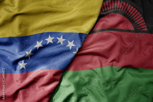 big waving national colorful flag of malawi and national flag of venezuela . macro