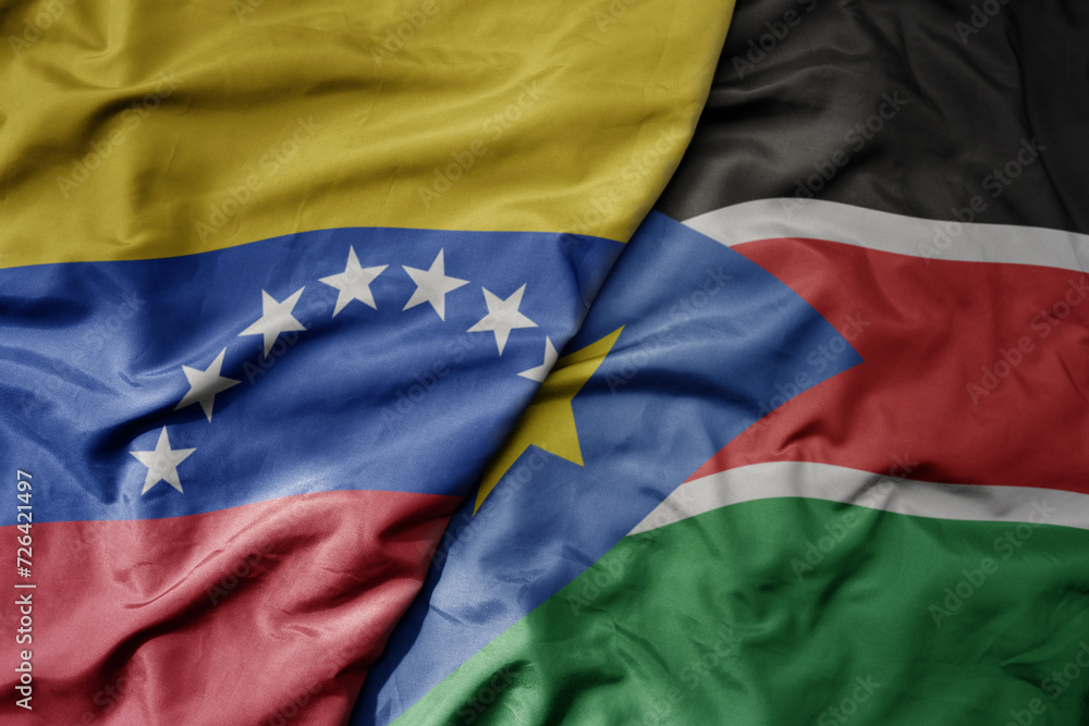 Fototapeta premium big waving national colorful flag of south sudan and national flag of venezuela . macro
