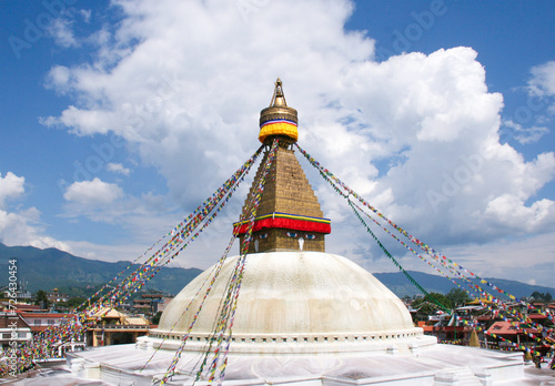 Stupa in Bodnath bei Kathmandu in Nepal heilige Gebetsstätte der Religion Buddhismus und Hinduismus mit bunten Gebetsfahnen, Sehenswürdigkeit und Pilgerstätte heilige Kuppel in weiß hell leuchtend 