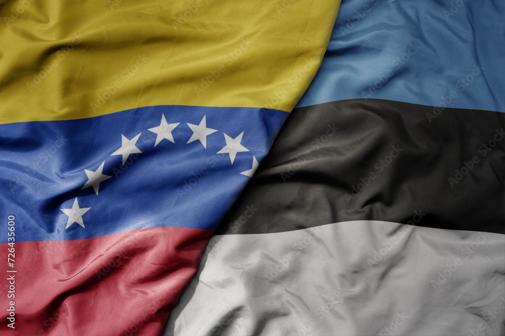 big waving national colorful flag of estonia and national flag of venezuela . macro