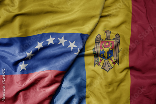 big waving national colorful flag of moldova and national flag of venezuela . macro