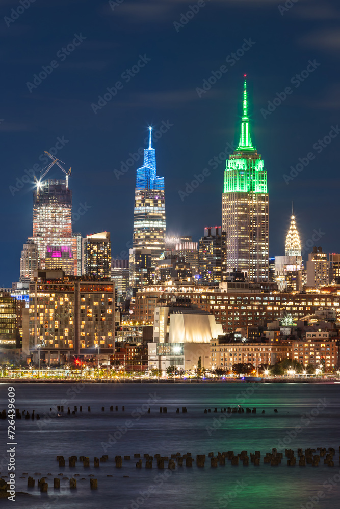 Illuminated New York City skyscrapers at night from across the Hudson River. Cityscape of West Village and Midtown Manhattan