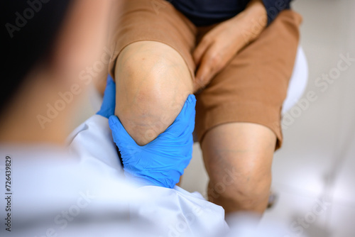 Fotografie Doctor examining the knee of a woman who has a knee injury Knee joint treatment by an orthopedic surgeon Treat knee joint pain caused by running or improper exercise