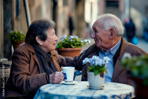 An elderly couple on a date, sitting at a table in their favorite street coffee with a cup of espresso, Valentine's Day card