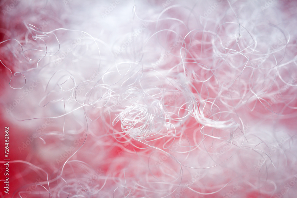 Fototapeta premium Extreme macro of polyester stable fiber on red background