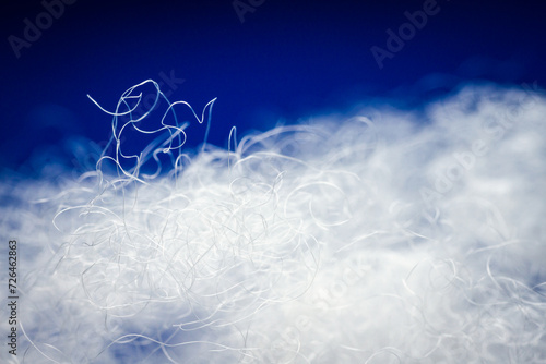 Extreme macro of polyester stable fiber on blue background photo