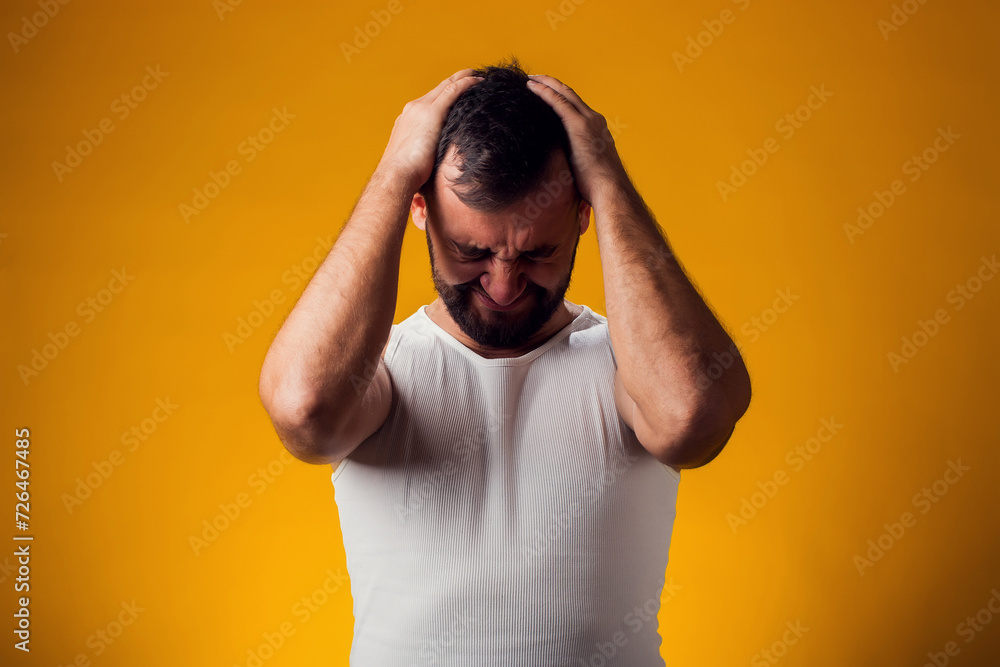Man suffering from headache desperate and stressed because pain and migraine. Hands on head. People, healthcare and medicine concept