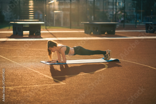 Girl doing sports outdoors on a sports ground