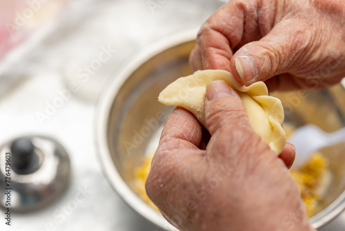 elder lady making Guangdong-style crispy pastry dumplings for Chinese New Year photo