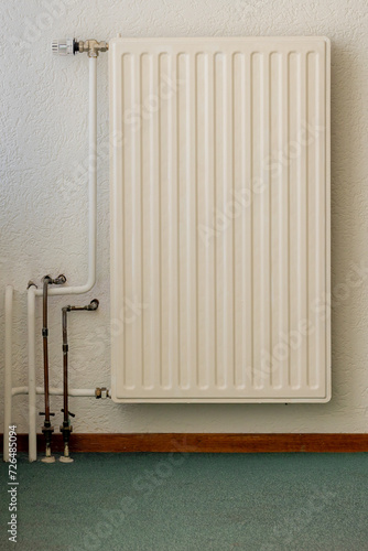 Wallpaper Mural Old classic realistic white steel panel heating radiator on white concrete background, A central heating system provides warmth to the whole interior of a building from one point to multiple rooms. Torontodigital.ca