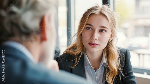 Wallpaper Mural Young Professional Woman in a Job Interview.A young, attentive woman listens carefully during a job interview, showcasing professionalism and keen interest. Torontodigital.ca
