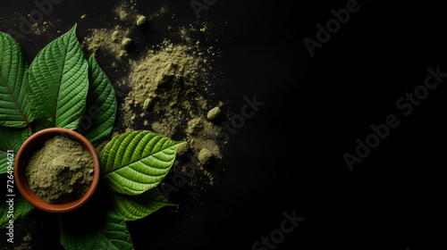 Mitragyna speciosa (kratom) leaves with powder in the wooden cup on black background