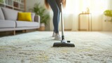 A woman is using a vacuum cleaner while cleaning the carpet in the house.