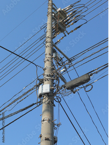 ケーブルと機器で複雑になった電柱。 日本の道路の風景。