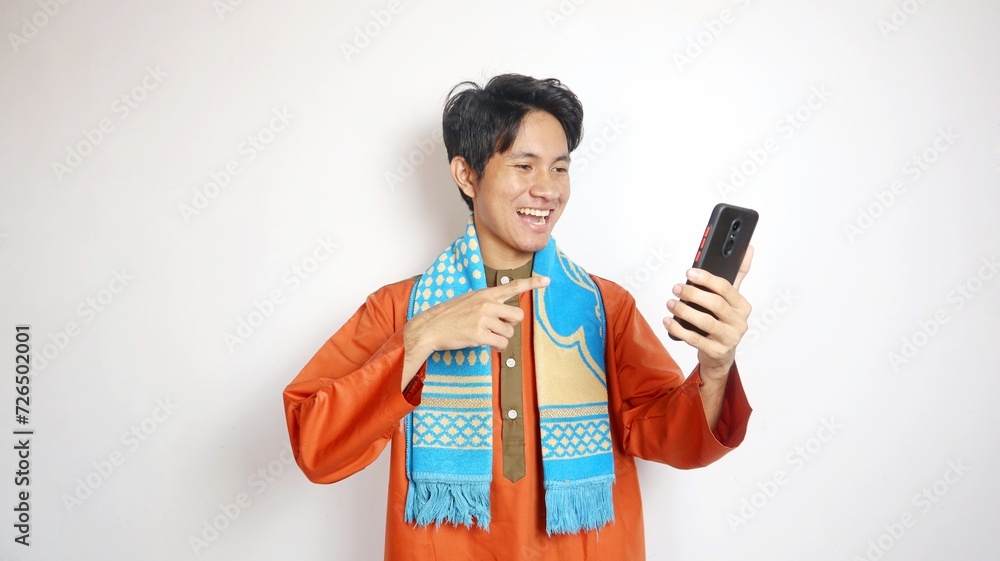 asian muslim man with holding gesture pointing towards smartphone asian muslim man with holding gesture pointing towards smartphone