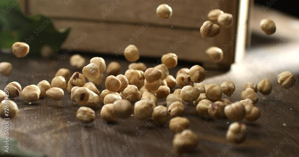 Super slow motion macro of fresh bio organic peeled dried hazelnuts are falling on wooden rustic table in kitchen of restaurant at 1000 fps. Super slow motion macro of fresh bio organic peeled dried hazelnuts are falling on wooden rustic table in kitchen of restaurant at 1000 fps.