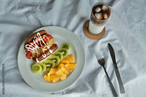 fruit and sandwich on a plate with coffee
