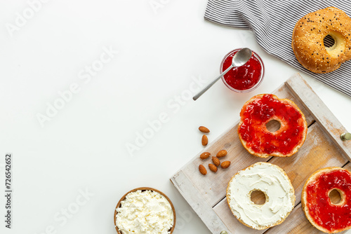Fresh baked bagels with cream on board, top view. Healthy breakfast background