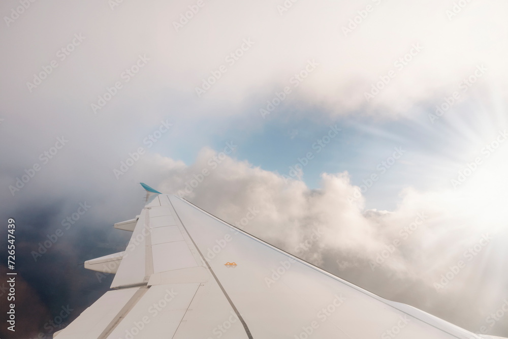 Wing of the plane on blue sky background Space for text.  Travel on an airplane concept.