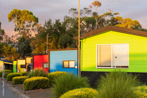 A row of brightly coloured cabins in a caravan parkin late afternoon light photo