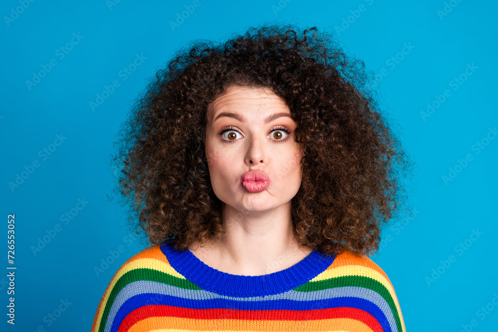 Photo portrait of pretty young girl pouted lips kiss girlfriend dressed stylish rainbow print outfit isolated on blue color background Photo portrait of pretty young girl pouted lips kiss girlfriend dressed stylish rainbow print outfit isolated on blue color background