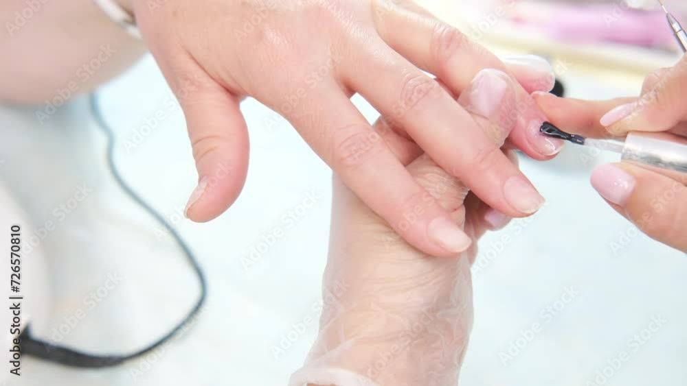 Manicure service of our own manufacture. The manicurist paints nails with transparent gel polish.Applying nail polish. Manicured nails. A manicure master paints nails. Manicure service of our own manufacture. The manicurist paints nails with transparent gel polish.Applying nail polish. Manicured nails. A manicure master paints nails.