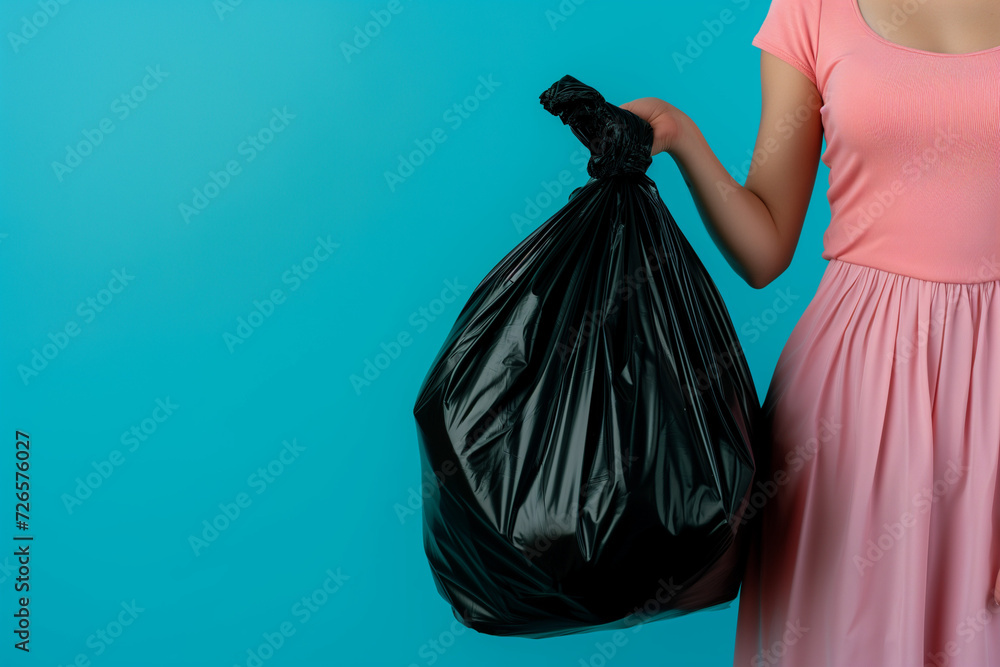 Obraz premium woman holding a bag of garbage