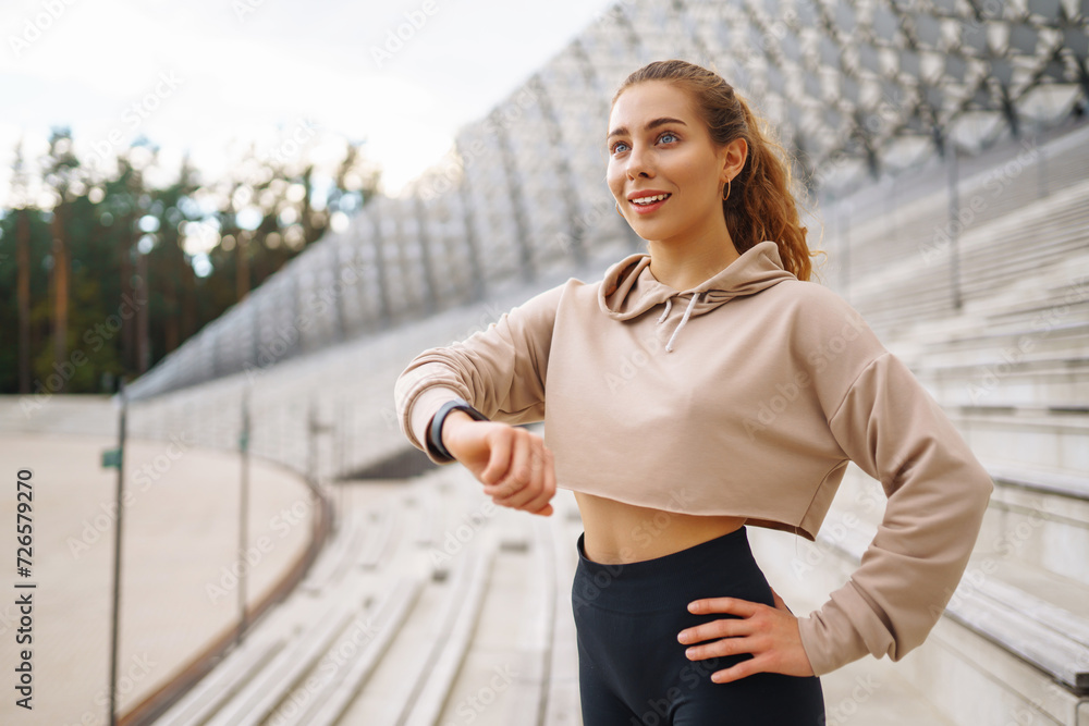 A woman does sports on the street. Fitness and a healthy lifestyle. The trainer does exercises for stretching the body. Sport, Active life, sports training, healthy lifestyle. A woman does sports on the street. Fitness and a healthy lifestyle. The trainer does exercises for stretching the body. Sport, Active life, sports training, healthy lifestyle.