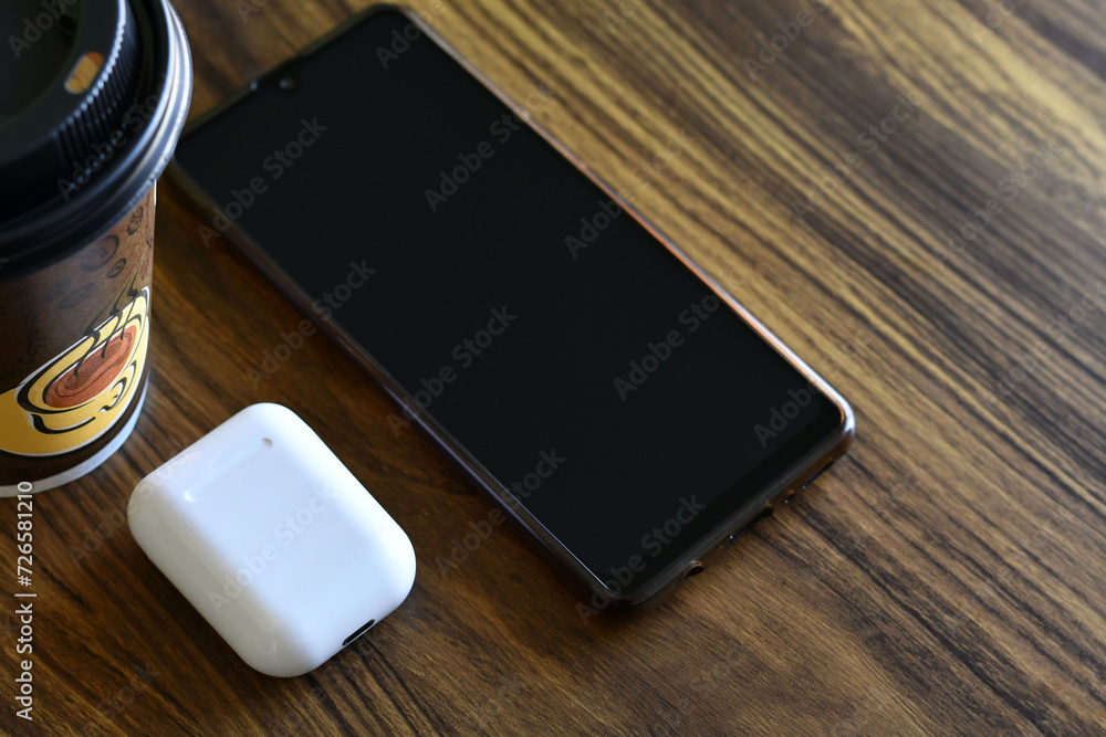 Teléfono celular, audífonos y café. Concepto de música y relajación. Espacio para texto. Teléfono celular, audífonos y café. Concepto de música y relajación. Espacio para texto.