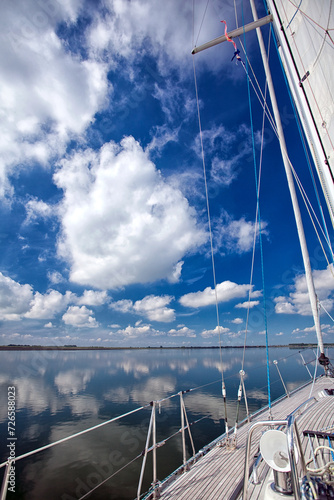 Zeilen op de Oosterschelde met reflectie van de bewolkte lucht in het water photo