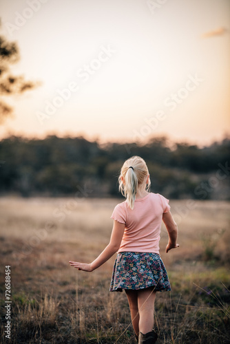 Girl facing into the landscape as she walks away photo