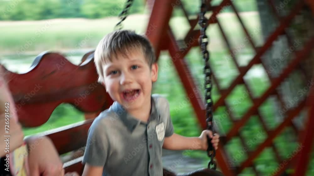 Mom with child boy kid rides on a swing and have fun talking in idyllic family place Mom with child boy kid rides on a swing and have fun talking in idyllic family place