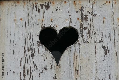 A heart sawed into a old wooden panel.