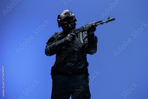 Soldier in black uniforms with weapon in studio. Concept Military warrior army tactical force to fight crime in city