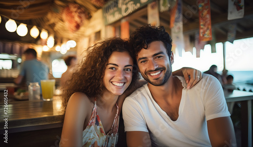 Um jovem casal sorrindo em um bar a beira mar photo
