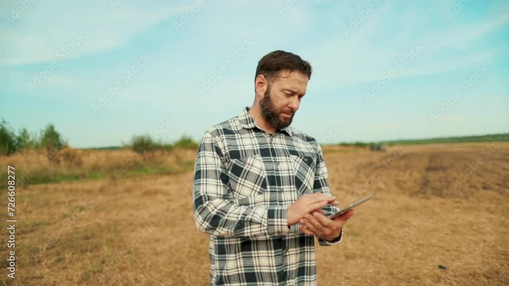 Farmer agronomist in the field. Farmer, business owner looking at tablet in wheat field. Agronomist with a tablet in his hands. A farmer-agronomist checks organic crops. Ecocultural farm. Farmer agronomist in the field. Farmer, business owner looking at tablet in wheat field. Agronomist with a tablet in his hands. A farmer-agronomist checks organic crops. Ecocultural farm.