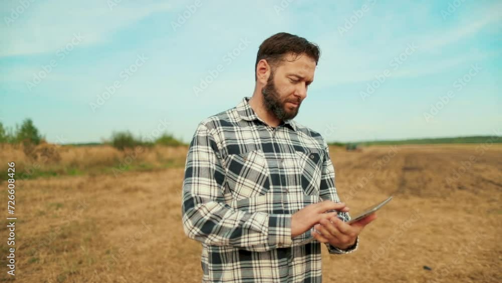 Farmer agronomist in the field. Farmer, business owner looking at tablet in wheat field. Agronomist with a tablet in his hands. A farmer-agronomist checks organic crops. Ecocultural farm. Farmer agronomist in the field. Farmer, business owner looking at tablet in wheat field. Agronomist with a tablet in his hands. A farmer-agronomist checks organic crops. Ecocultural farm.