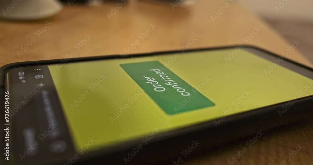 Pressing the Pay Now button on the smartphone screen. Order confirmed, response to purchase of goods, concept of online payment, online store. Close-up, side view. Pressing the Pay Now button on the smartphone screen. Order confirmed, response to purchase of goods, concept of online payment, online store. Close-up, side view.