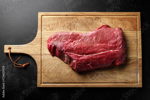 Bild auf Leinwand Beef meat entrecote on a cutting board, raw beef meat fillet on black background