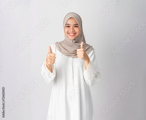 muslim lady wearing white muslim dress and hijab showing the thumbs up